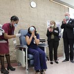 Governor Murphy, First Lady Murphy, and Health Commissioner Periscelli watch Beniquez after she gets her vaccine; Beniquez is smilin and clasping her hands